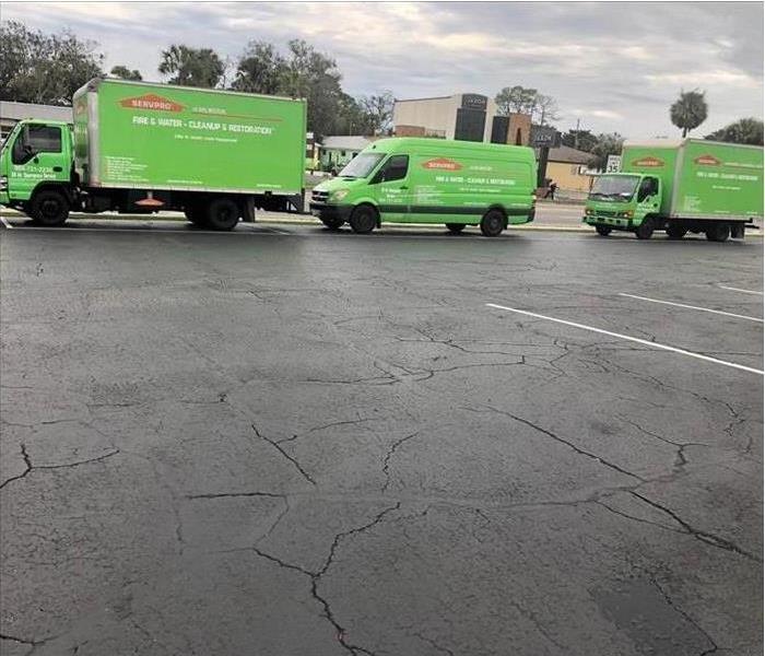 two truck box and a van, three green vehicles on the road